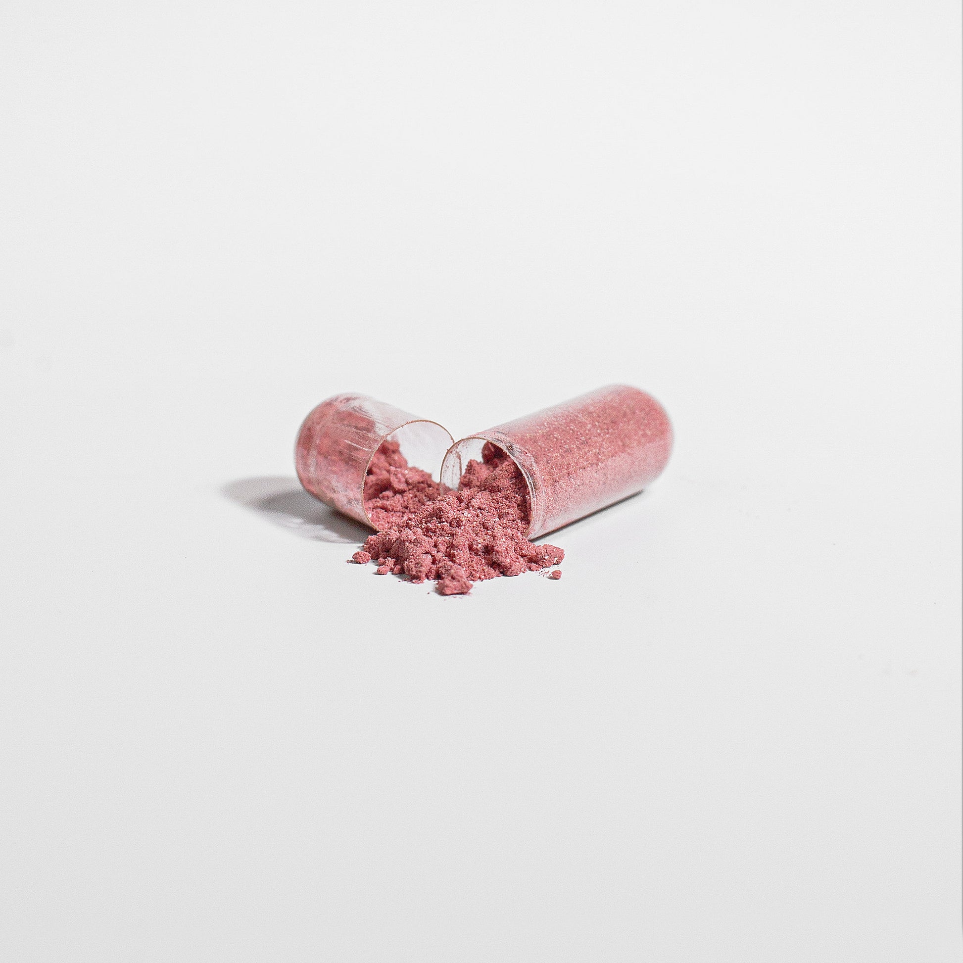 Fuelchemy beetroot capsules supplement with pink powder spilled from the capsules