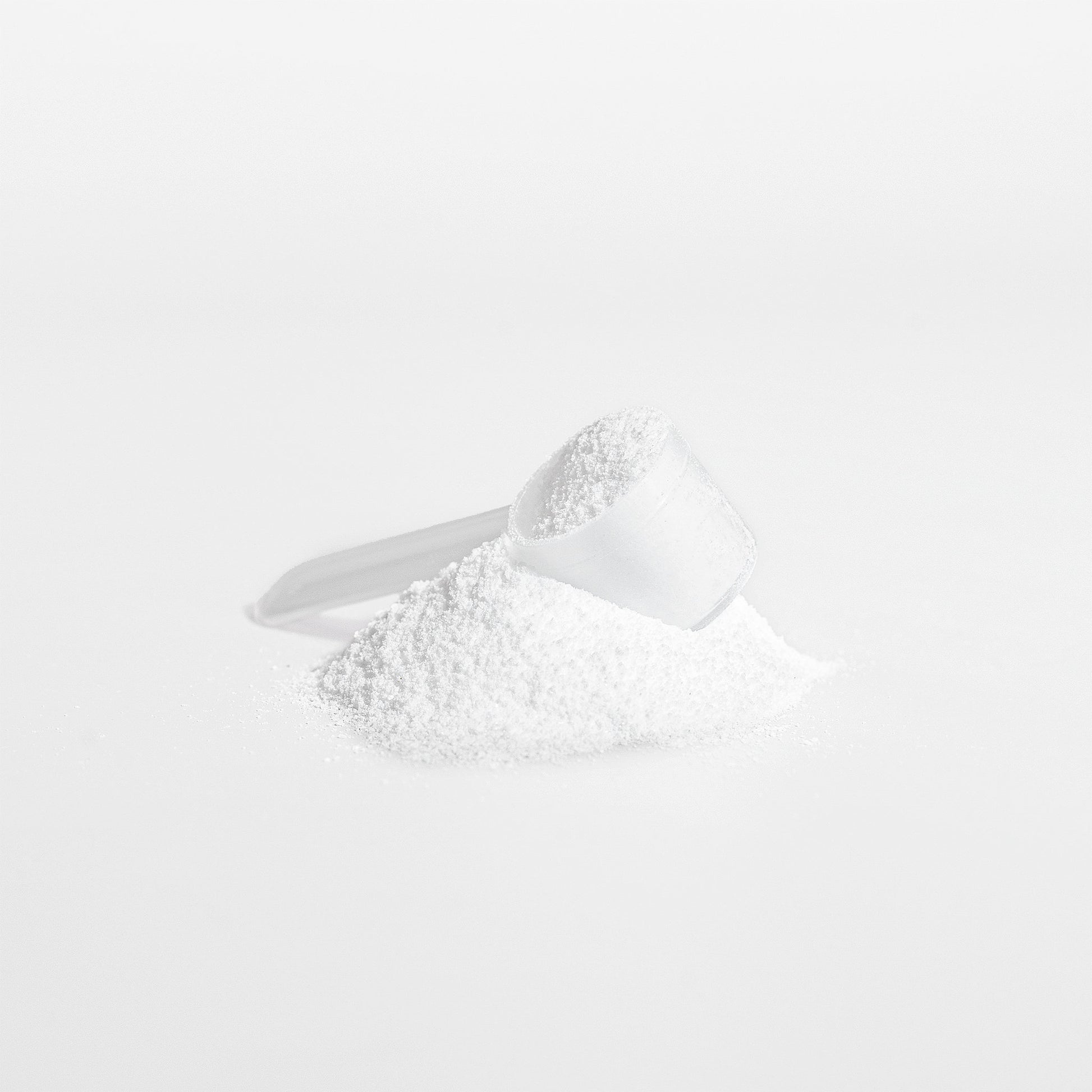 White Fuelchemy Creatine Monohydrate Powder for Athletes in a Measuring Scoop for Performance Boost