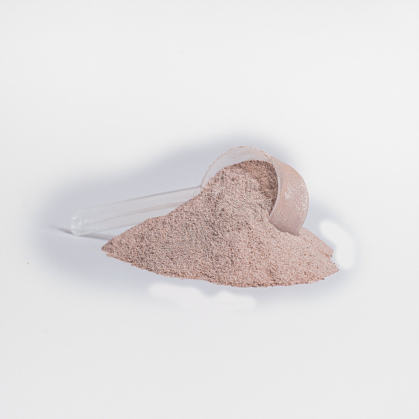 Fuelchemy vanilla plant protein powder in a scoop with a pile next to it on a white background