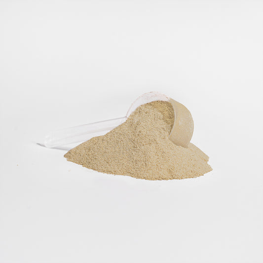 Fuelchemy vanilla whey protein supplement in a scoop with fine powder spilling out